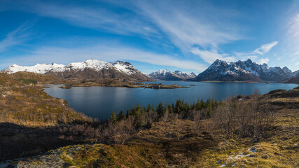 Europe, Norway. Snow covered mountains surround the bay on Vestvagoy, a part of the Lofoten Islands in Nordland.