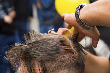The hairdresser cuts and combs the man. Barber's hands with scissors and a hairbrush