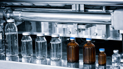 pharmaceutical industry, medicine pills are filling in the  glass bottle on production line machine...