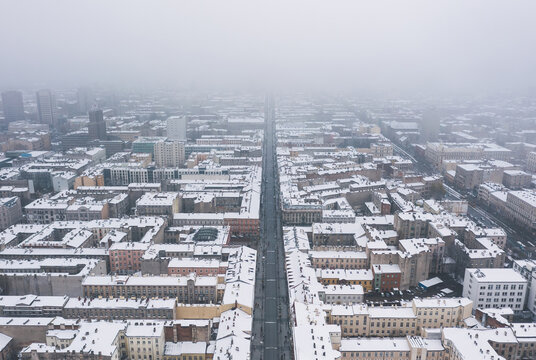 Aerial winter cityscape of Lodz, Poland.  View along the famous tourist attraction - Piotrkowska Street with rooftops covered in snow.
