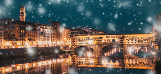 snowfall  over Florence Ponte Vecchio on river Arno at night, winter in Italy
