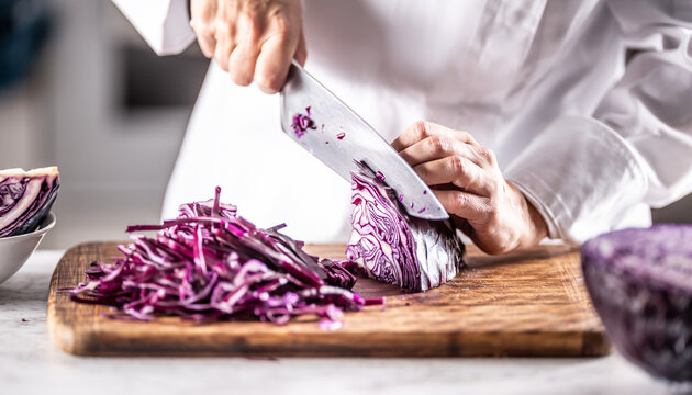 Detail of a chef cutting red cabbage to thin slices