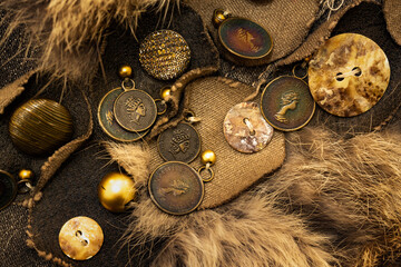 Design made with buttons, beads, fabric scraps and metal pendants on a denim fabric with fur. Vintage colors background photo.