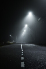 A very foggy night road leading into the unknown.