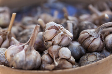 Garlic cloves on the market in wooden bowl
