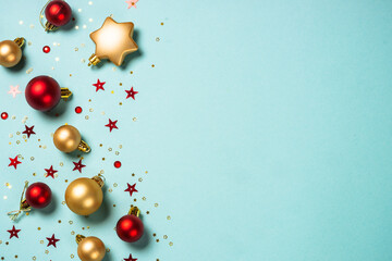 Christmas decorations on blue. Red and golden decor. Flat lay image with copy space.