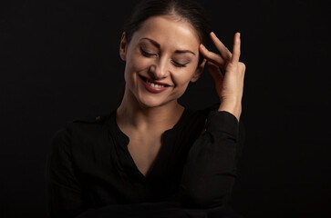 Beautiful makeup woman with long hair laughing with closed eyes on black background. Closeup portrait