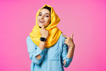 woman wearing yellow hijab electronic watch technology pink background