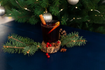 Christmas mulled wine with cinnamon stick, orange, anise and cloves on a blue background. Winter...