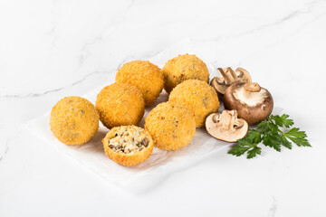 Champignons Croquettes, deep fried balls with chicken, cheese and parsley on paper on a white background