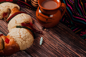 Rosca de reyes or Epiphany cake and clay mug of mexican hot chocolate on a wooden table in Mexico Latin America	