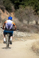 Obraz na płótnie Canvas A Mature Man Mountain Biking in the California Hills on a Mountain Trail