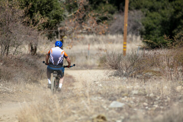 A Mature Man Mountain Biking in the California Hills on a Mountain Trail