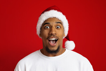 Closeup of surprised black guy in santa hat