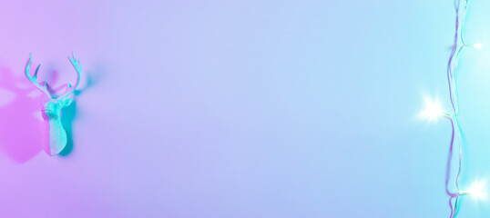 Stylish Christmas neon winter background. Holiday decoration bauble ball on neon gradient backdrop. Minimal abstract xmas reindeer. Happy new year copy space.