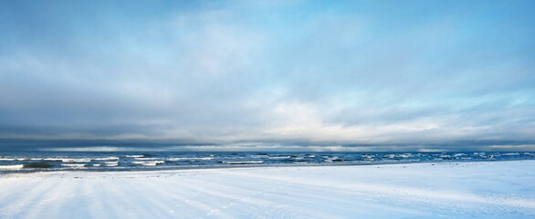 A view of the snow-covered Baltic sea coast at sunset. Coniferous forest in the background....