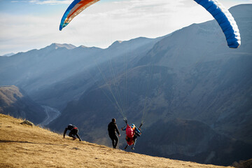 Paraglide silhouette over mountain peaks. High quality photo