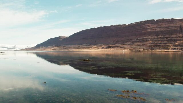 Over Reflective Water Of Fjord Towards Mountains