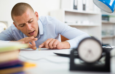 Office worker messing around - playing with coin while sitting at the table