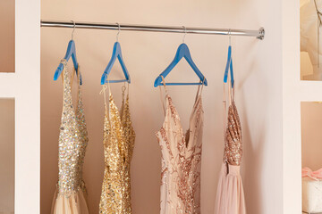Pink women's dresses hang on wooden hangers