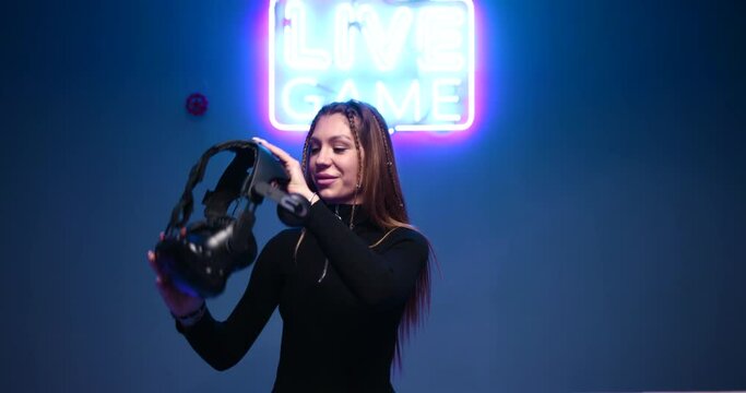 Young woman wears a virtual reality helmet.