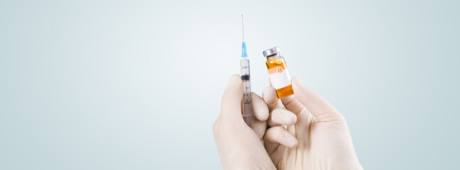 Hand holding syringe with vaccine against corona virus.