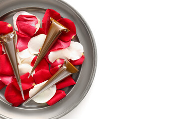 Henna paints and rose petals on tray