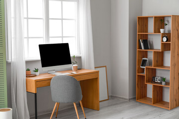 Interior of modern office with wooden table and shelving unit