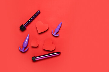 Sex toys and hearts on color background