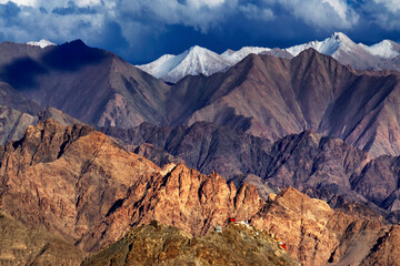 Rocky landscape of Leh City with ice peaks in background , blue sky with clouds, Ladakh, Jammu and Kashmir, India