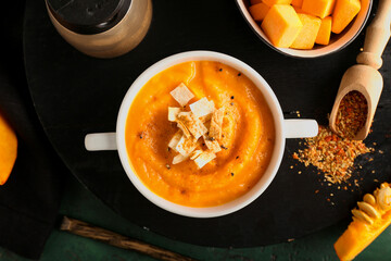 Pot with delicious pumpkin cream soup on table