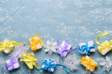 Christmas gifts and decorations on color background