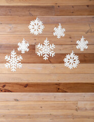 Obraz na płótnie Canvas White snowflakes hanging near wooden wall