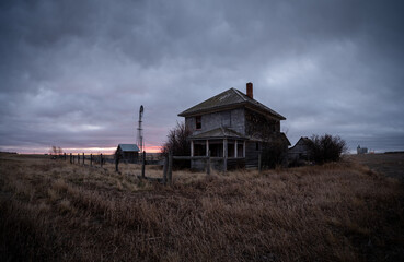 Abandoned and broken down old farms and homesteads with dark and ominous skies in Alberta, Canada