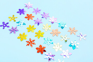 Beautiful confetti in shape of snowflakes on blue background