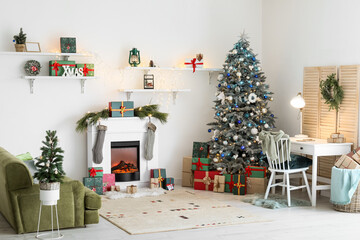 Interior of festive living room with modern workplace, Christmas trees and fireplace