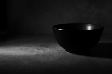 View of an empty black bowl with a chiaroscuro style