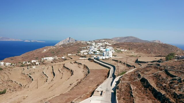 Aerial flying forward follow quad bike explore Folegandros island, Greece