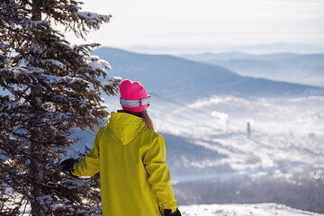 Woman skier looks into the distance, at the blue mountains. - Powered by Adobe