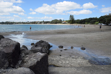 A beautiful coastal scene on Auckland's North Shore, with blue sky and calm sea