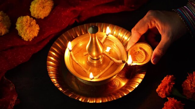 Indian woman holding lighting oil lamp Pongal Onam Diwali vishu celebration Indian festival 4K video footage decorating marigold flowers Nilavilakku Rangoli Kerala Tamil nadu North India Mumbai Delhi 