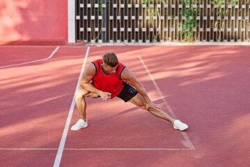 athletic man in red jersey on the sports ground exercise