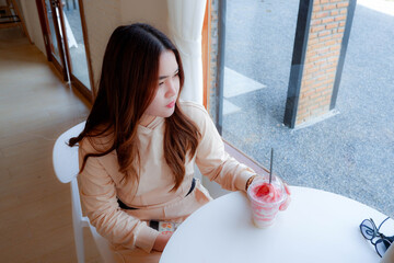 girl sitting and drinking strawberry smoothie alone in the cafe