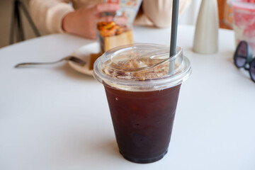 Black coffee in a clear plastic cup on the table
