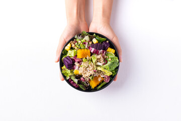 Fresh organic vegetables salad with quinoa seed in bowl holding by hand on white background, Healthy Vegan food, Top view