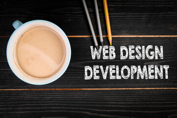 Web Design Development. Coffee mug and colored pencils on a black textured wooden background