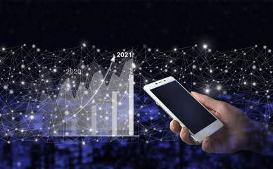 Business strategy. Digital marketing. Hand hold white smartphone with digital hologram growth graph chart sign on city dark blurred background. Business growth concept year 2022.