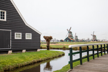 Europe, Netherlands, Zaanse Schans. Historic windmills seen from bridge.