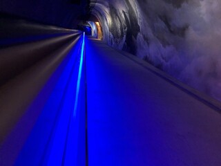 A blue light trail leads to the end of the tunnel.