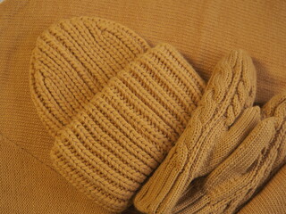 Fototapeta na wymiar a set of warm yellow clothes. hat mittens and scarf